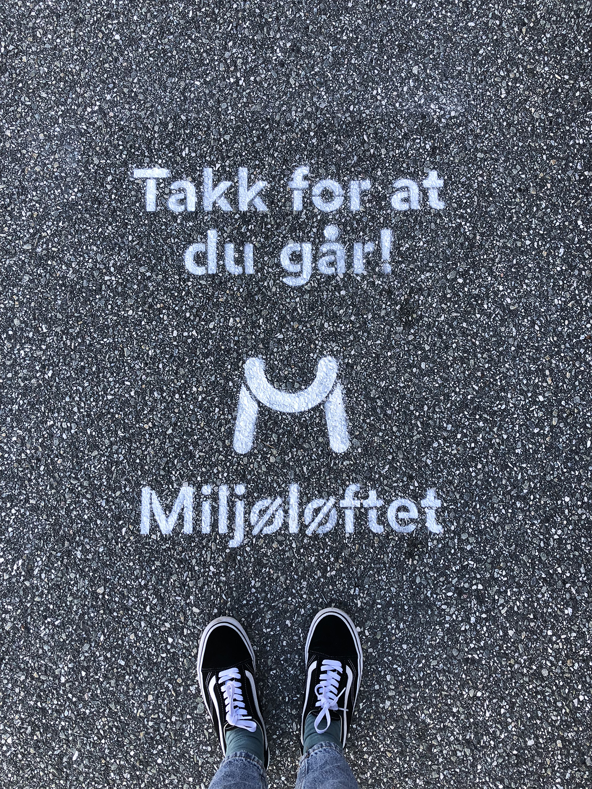 Stensil på asfalten med teksten «Takk for at du går!» og Miljøløftet-logoen, med et par sko synlig i forkant.