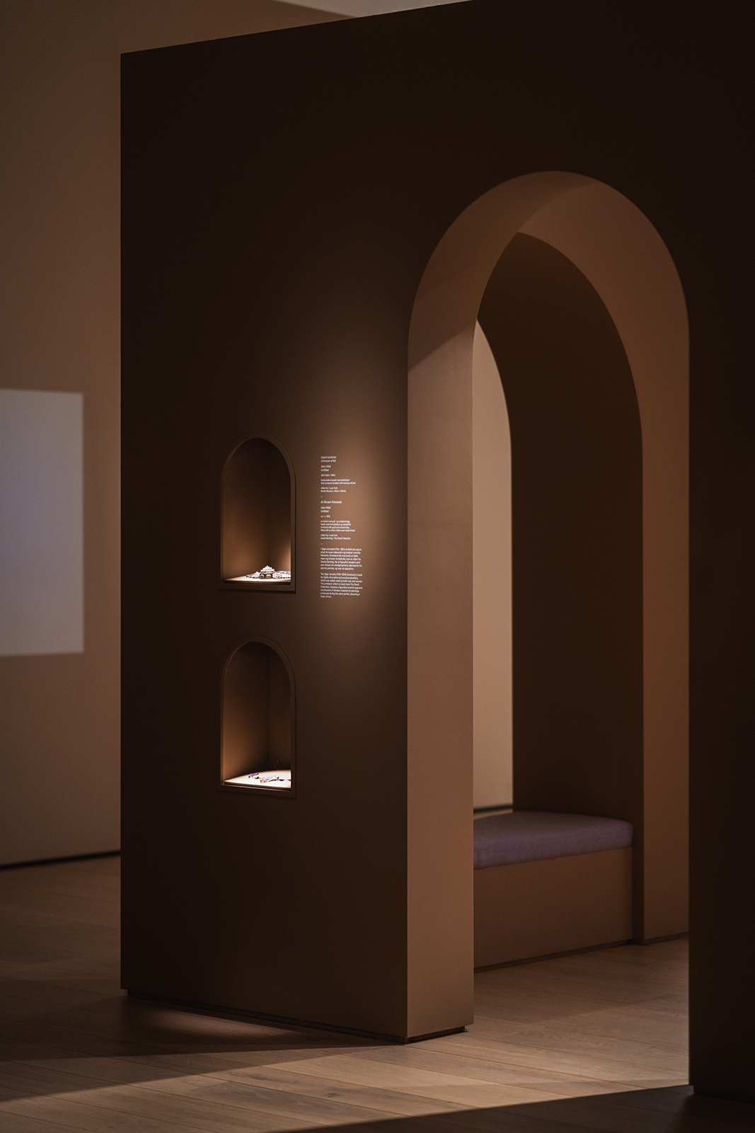 Arkitektonisk element med to små innebygde nisjer for smykker og en stor buegang som leder til et sitteområde.